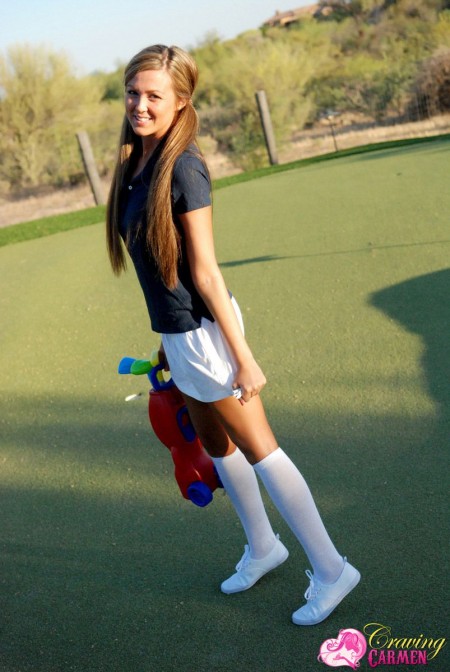 Девочка с выбритой киской Craving Carmen в белой мини юбке развлекается сама с собой на гольф-лужайке
