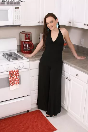 Детка с бритой киской Krystal Jordan снимает свой черный наряд на кухне